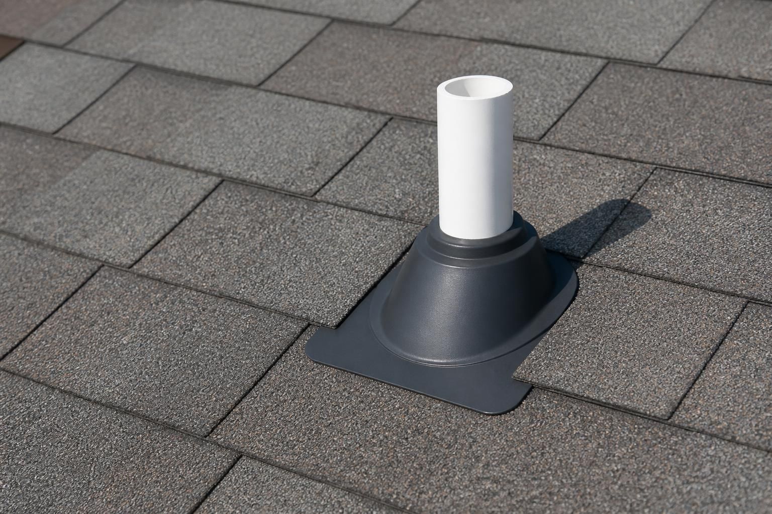 Neatly sealed pipe boot on a finished shingle roof.